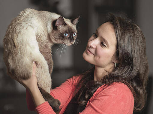 Frau hält Katze hoch