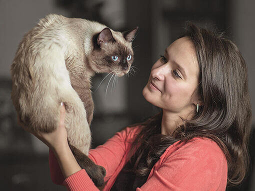 Frau hält Katze hoch